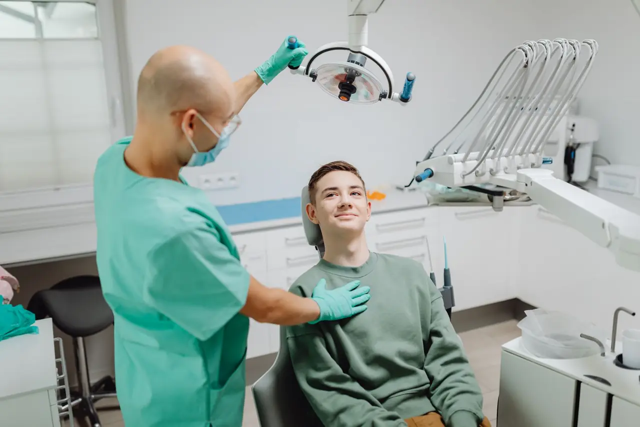 A dentist examining a patient under the dental light