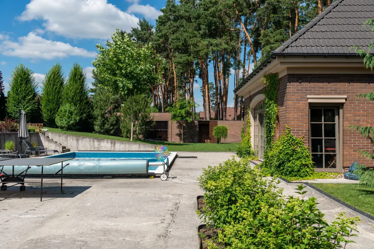 A residential backyard swimming pool with the cover rolled back