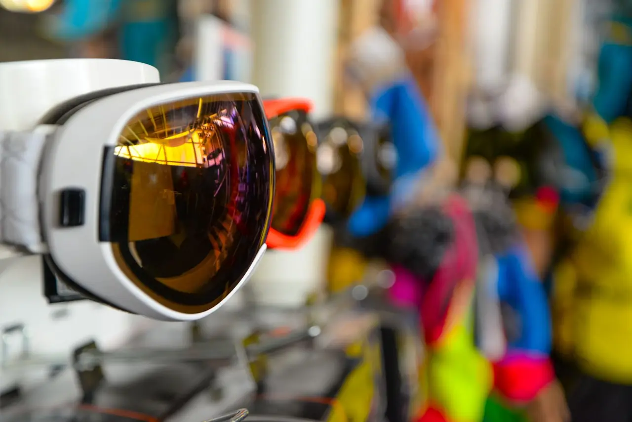 Vibrant ski goggles displayed in a sports store, showcasing reflective lenses and colorful designs.