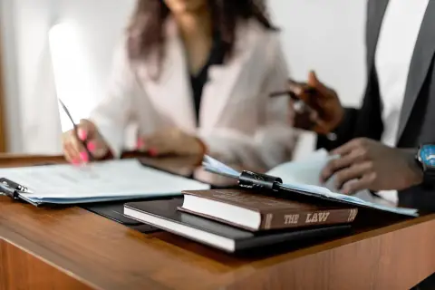 Two lawyers reviewing documents beside law books